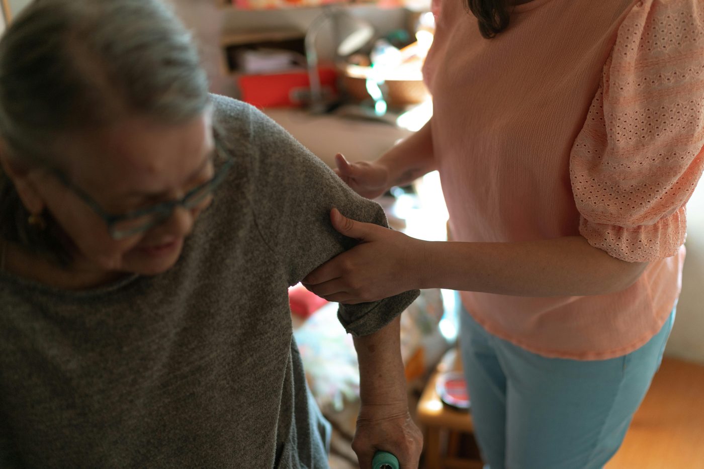 A caregiver helping a senior stand at home